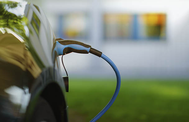 Electric Car is charging in front of house