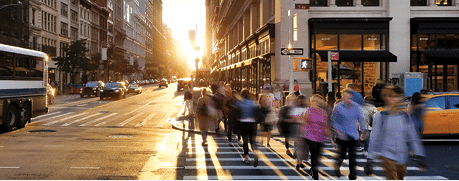 Crowd of anonymous people in motion walking across the busy intersection of Fifth Avenue and 23rd Street in Midtown Manhattan, New York City NYC