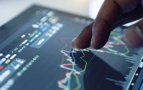 Market Analyze with Digital Monitor focus on tip of finger.