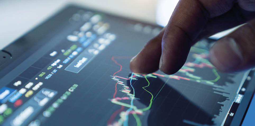 Market Analyze with Digital Monitor focus on tip of finger.