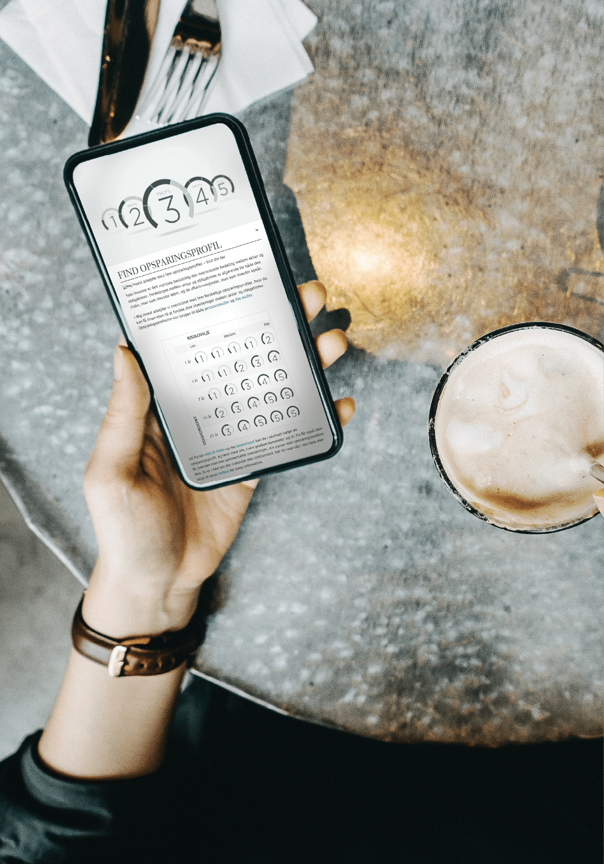 Overhead view of woman checking financial trading data on smartphone while drinking coffee in cafe